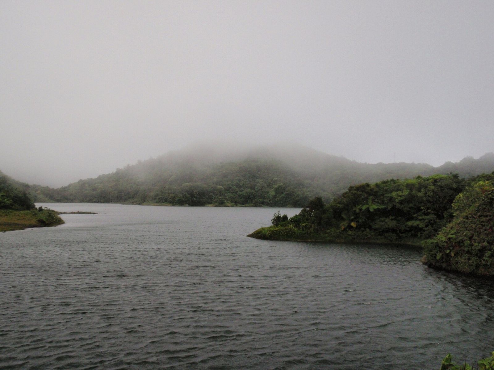 Mist hangs over the forested hills around Freshwater Lake in Dominica's Morne Trois Pitons National Park.