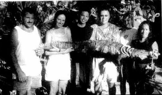 Students holding a large American crocodile in the mangroves of Roatán