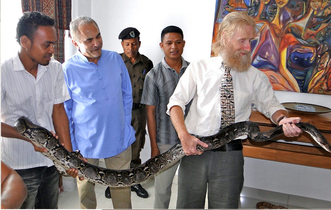President José Ramos-Horta watches as Mark O'Shea and a Timorese student hold a large reticulated python